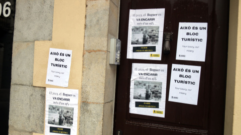 Cartells que els manifestants van enganxar per assenyalar un bloc de pisos turístics al carrer Santa Clara de Girona, en una manifestació a principis d'aquest mes de juliol