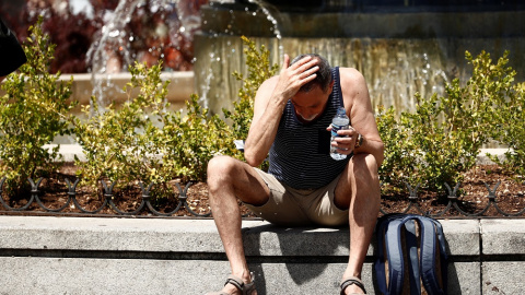 Un hombre se echa agua por la cara durante la ola de calor en Madrid.