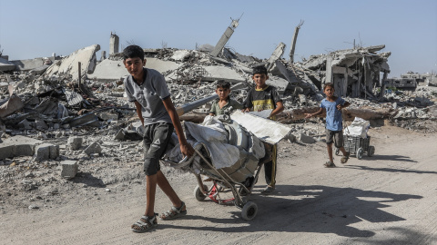 Niños palestinos pasan junto a los restos de edificios destruidos mientras los residentes de Khan Yunis regresan a sus hogares, mayormente devastados por la invasión israelí.