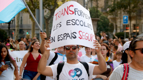 Una persona sosté una pancarta on es pot llegir transformem les escoles en espais segurs.