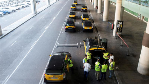 Un grupo de taxistas permanecen parados con sus vehículos en el Aeropuerto de Barcelona durante la huelga de taxis este miércoles. / EFE