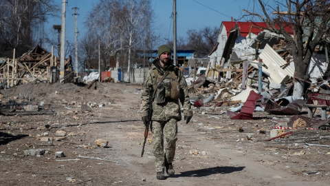 Un soldado ucraniano pasea por un barrio destruido en el este de la región de Kiev.