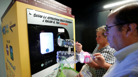 Dos vecinos de Roma haciendo uso de esta iniciativa que une reciclaje y transporte público. / Reuters