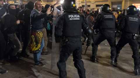 Un mediador pacifista trata de impedir que antidisturbios y encapuchados se enfrenten en Via Laietana, junto a Urquinaona, el pasado sábado, 18 de octubre, por la noche. GUILLEM SANS