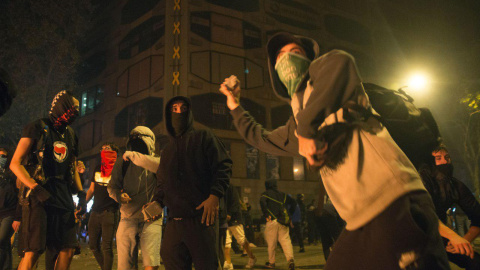 Jóvenes encapuchados lanzan piedras contra la Policía en Barcelona. GUILLEM SANS