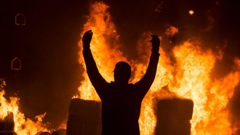 Un joven antisistema celebra el incendio de una barricada en el centro de Barcelona. GUILLEM SANS