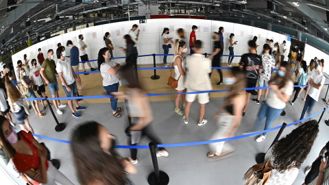 Cientos de personas, entre los que se encuentran los jóvenes mayores de 16 años, hacen cola en el hospital Enfermera Isabel Zendal de Madrid, para ser vacunados frente al coronavirus, el pasado martes 13 de julio.