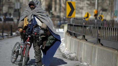 Un ciudadano de Nueva York sin hogar caminando por el puente de Brooklyn. / Reuters