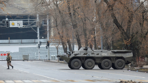 Un miembro del servicio kazajo camina cerca de un transporte blindado tras las protestas provocadas por el aumento del precio del combustible en Almaty, Kazajistán, el 7 de enero de 2022.