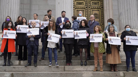 Varios diputados posan a las puertas del Congreso de los Diputados con carteles con fotos de Pablo González y la etiqueta #FreePablo este 30 de marzo de 2022.