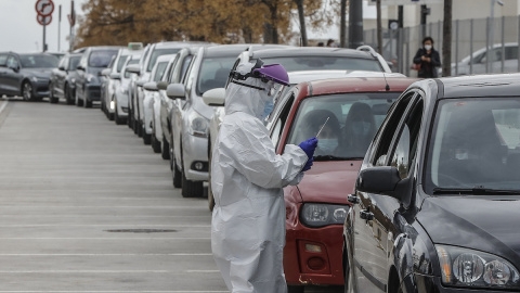 Un sanitario realiza una prueba PCR a una persona desde su vehículo para la detección del coronavirus a las puertas del Hospital de Campaña próximo al de La Fe, en València, a 25 de enero de 2021.