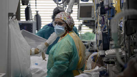 Dos sanitarios atienden a un paciente en la Unidad de Cuidados Intensivos (UCI) dedicada a enfermos de coronavirus del Hospital Universitario Ramón y Cajal, en Madrid (España), a 8 de octubre de 2020.