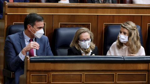 El presidente del Gobierno, Pedro Sánchez, conversa con la vicepresidenta segunda y ministra de Trabajo, Yolanda Díaz (d), en presencia de  (i) junto con la vicepresidenta primera y ministra de Asuntos Económicos, Nadia Calviño (c)  durante la sesión