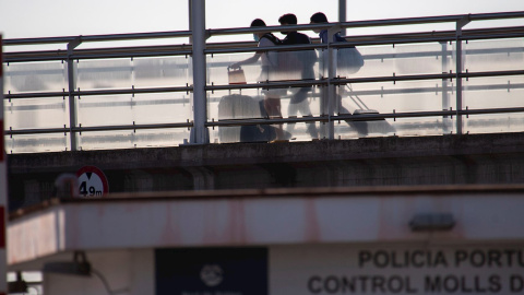 Varios estudiantes, que se encontraban en cuarentena por el macrobrote de covid-19, se dirigen al "barco burbuja" para salir hacia Valencia, este jueves, en el puerto de Palma de Mallorca.