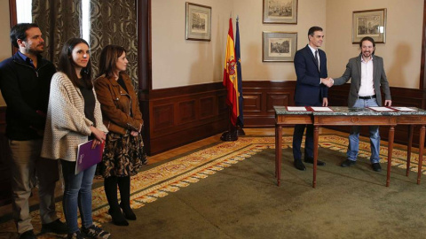 GRAF7665 MADRID, 12/112019.- El presidente del Gobierno español en funciones, el socialista Pedro Sánchez (c), y el líder de Unidas Podemos, Pablo Iglesias,d se estrechan las manos tras llegar hoy a un acuerdo para la formación de un Ejecutivo en Espa