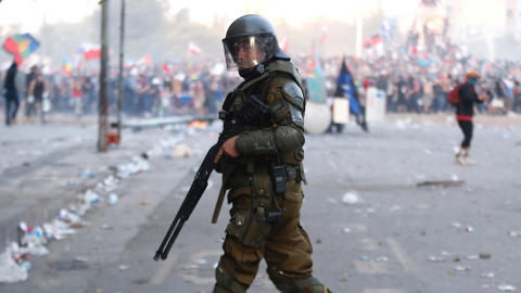 Un miembro de los Carabineros, el cuerpo policial de Chile, frente a los manifestantes en la céntrica Plaza Italia de Santiago. EFE/Alberto Valdés