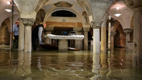 Operarios vacían la cripta de la basílica de San Marcos, donde el nivel del agua llegó a los 110 centímetros durante la noche. REUTERS/Manuel Silvestri