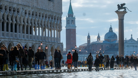 14/11/2019.- La gente camina por una pasarela improvisada sobre la Plaza de San Marcos inundada, Venecia, Italia. REUTERS / Manuel Silvestri