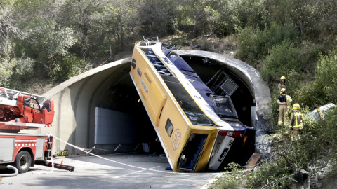 L'autobús bolcat a la C-32, amb els serveis d'emergències treballant al lloc