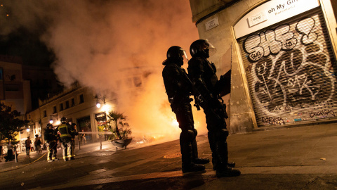 Dos antidisturbios de los Mossos d'Esquadra, apostados en una esquina tras las cargas policiales en Barcelona el pasado 18 de octubre.-EFE