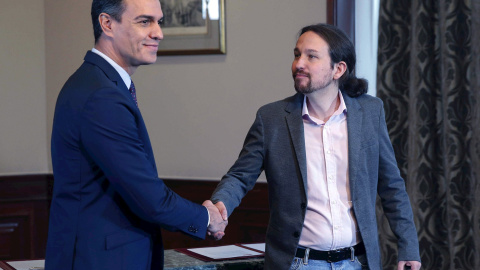 12/112019.- El presidente del Gobierno español en funciones, Pedro Sánchez y el líder de Podemos, Pablo Iglesias, se estrechan la mano en el Congreso de los Diputados donde este martes firmaron un acuerdo para la formación de un Ejecutivo. EFE/Paco Ca