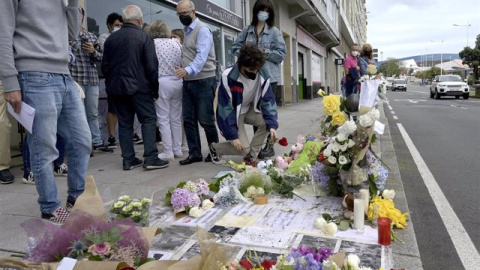 Un joven posa una rosa en el altar colocado en la acera donde fue golpeado Samuel.