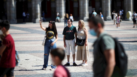 Varias personas pasean con y sin mascarilla, en la Plaza Mayor de Madrid. - EFE