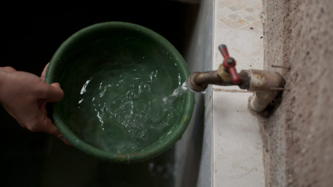 Detalle de la mano de una persona sacando agua del grifo.