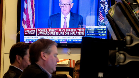 Un monitor de televisión en el patio de negociación de la Bolsa de Nueva York (NYSE, en sus siglas en inglés), en Wall Street, ofrece la comparecencia del presidente de la Reserva Federal, Jerome Powell, tras la reunión en la que se ha acordado la pri