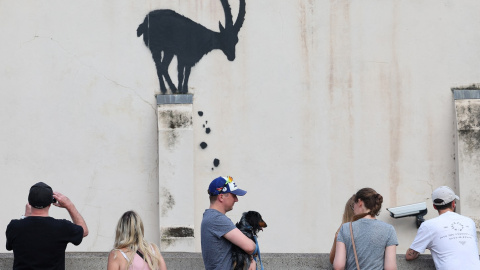 Varias personas observan la pintada del artista callejero Banksy, in Kew, en el oeste de Londres. REUTERS/Toby Melville