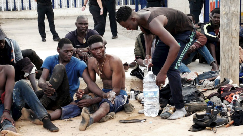 Migrantes en MelillaUn grupo de inmigrantes subsaharianos aguardan tras conseguir saltar la valla fronteriza de Melilla este jueves.