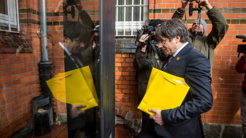 Carles Puigdemont entra en la prisión de Neumünster (Alemania), donde estuvo detenido hace un año, para hacer una donación a la biblioteca de la institución. - EFE