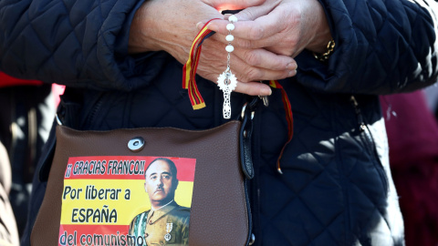 Una mujer franquista sostiene un rosario mientras reza afuera del cementerio Mingorrubio-El Pardo, en Madrid. REUTERS / Sergio Perez