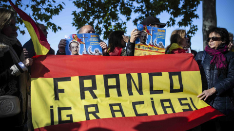 Varios franquistas sostienen una bandera de España con un texto pintado sobre ella que pone "Franco Gracias" en los alrededores del cementerio de Mingorrubio-El Pardo. / Jairo Vargas