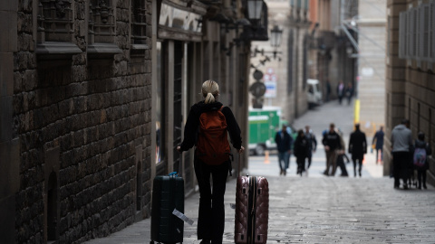 09/08/2024 Una persona camina con dos maletas en Barcelona, Catalunya. Foto de arhivo.