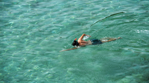 Un bañista nada en la cala de Alcalfar en Menorca, este miércoles 26 de octubre de 2022, donde se pueden llegar a alcanzar los 33 grados.