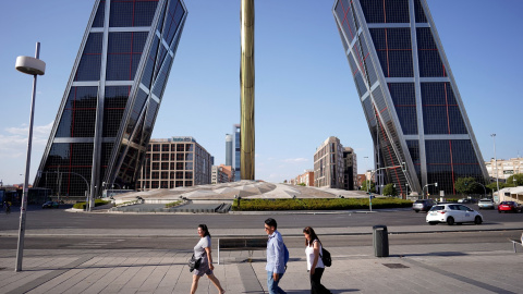 Varias personas pasan por la madrileña Plaza de Castilla, en plena cuarta ola de calor. REUTERS/Ana Beltran