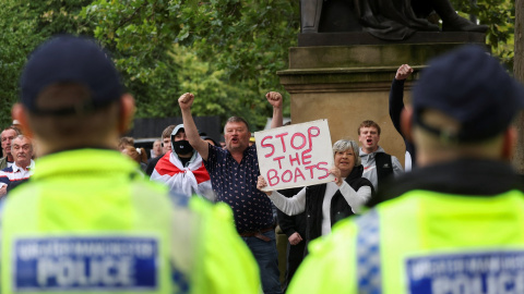 Agentes de la policía británica frente a un grupo de manifestantes ultras contra los migrantes, en la localidad de Mánchester, durante la ola de violencia racista en el Reino Unido. REUTERS/Manon Cruz