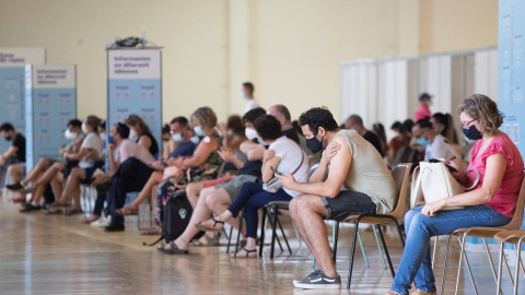 Una cola de personas en una sala del centro de vacunación masiva, instalado en la Fira de Cornellà (Barcelona).