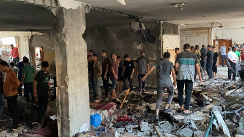 Palestinos inspeccionan los daños tras un ataque israelí que mató al menos a 100 personas en una escuela que albergaba desplazados en la ciudad de Gaza.