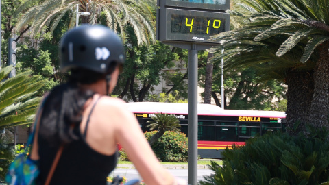 14/08/2024 Una joven circula en bicicleta en Sevilla, donde las temperaturas han superado los 40ºC esta semana. Foto de archivo.