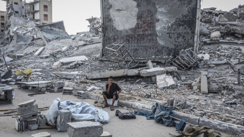 Un palestino sentado junto a los escombros de un edificio tras un ataque israelí