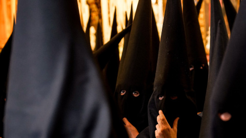 Nazarenos de la Hermandad de Santa Genoveva, en el interior del templo, en la Semana Santa de Sevilla, a 11 de abril del 2022.