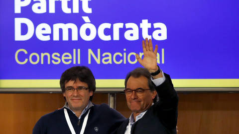 El presidente de la Generalitat, Carles Puigdemont, saluda al expresidente Artur Mas, tras su intervención ante el consell nacional del PDeCat. EFE/Alberto Estévez