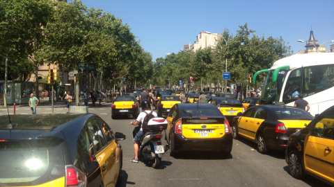 Taxistes en marxa lenta bloquegen els carrils centrals de la Gran Via de Barcelona, a l'alçada de Plaça Universitat. / LC.