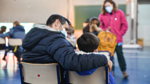 Un niño espera para recibir la vacuna contra el coronavirus en el CEIP Campanar, a 13 de enero de 2022, en València.