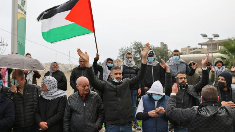 Los árabes israelíes gritan consignas y ondean banderas nacionales palestinas mientras organizan una protesta en la ciudad mayoritariamente árabe de Umm al-Fahm, en el norte de Israel, en solidaridad con las comunidades beduinas del desierto de Negev c