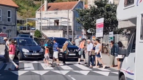 Vecinos de O Hío (Pontevedra) cortan el tráfico cruzando la calle de forma ininterrumpida.