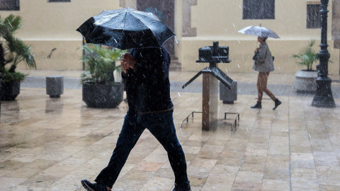 Una persona se protege de la lluvia con un paraguas, esta mañana en València./EFE