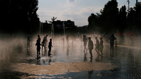 Niños juegan con el agua que brota de una fuente pública de la zona de Madrid Río. REUTERS/Javier Barbancho